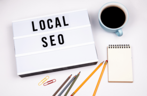 Local SEO written on a board with some coffee, notepad and pencils placed aesthetically