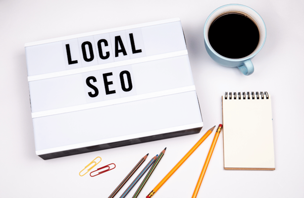 Local SEO written on a board with some coffee, notepad and pencils placed aesthetically