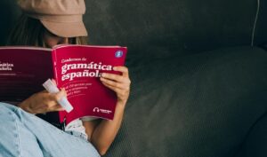 woman learning Spanish with a book to become a Freelance Translator